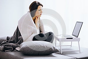 Woman with flue sitting at home consulting her doctor via internet conversation