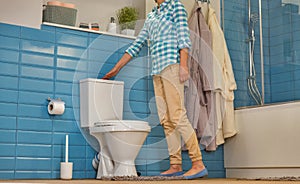 Woman flushes the toilet in the bathroom, bottom view photo