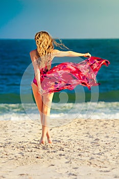 Woman in fluttering dress on beach