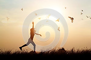 Woman and flying birds enjoying life in nature on sunset photo