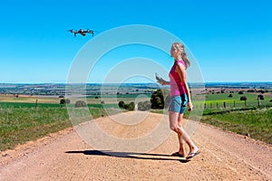 Woman flying a drone in rural landscape