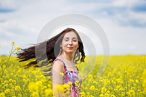 Woman with flying hair on yellow field