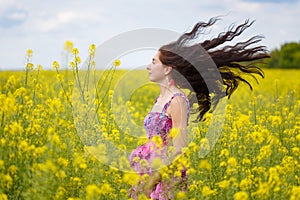 Woman with flying hair on yellow field