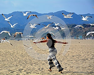 Woman flying with sea birds on the beach