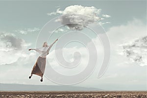 Woman flying in the sky carried by a cloud photo