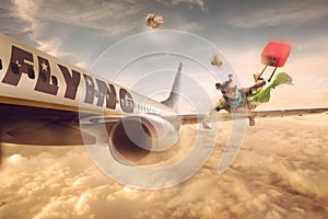 Woman flying in the wing of a moving plane, over clouds with lug photo