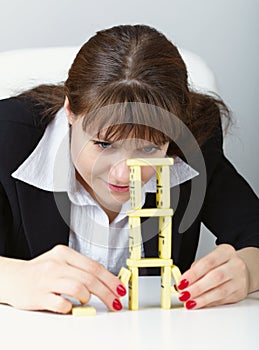 Woman is focused to build a tower with domino