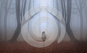 Woman in a foggy forest during autumn
