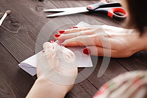 Woman fold sheet of paper while do origami