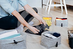 Woman folding clothes on the floor, organizing stuff and laundry photo