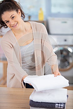 woman folding clothes in utility room