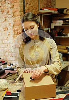 woman folds packing box in sewing workshop