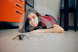 Woman Following a Big Insect on the Kitchen Floor