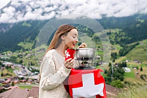 Woman with fondue in the mountains