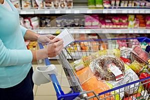 Woman with food in shopping cart at supermarket