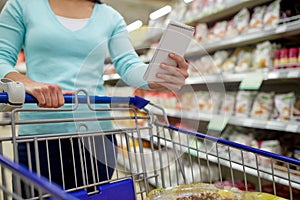 Woman with food in shopping cart at supermarket