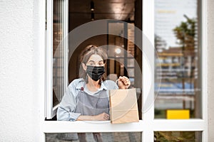 Woman with food to take away in the shop window