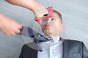 Woman foot in high-heeled shoes stands on man head photo