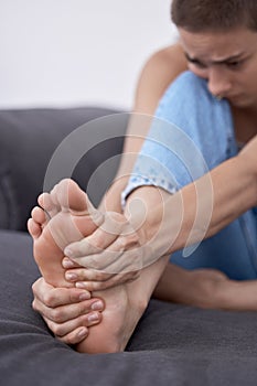 Woman, foot pain and muscle ache in home, massage and bruise or cramps for injury or accident. Female person, tender and