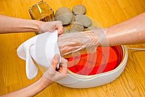 Woman foot in paraffin bath at the spa