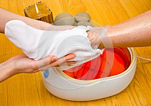 Woman foot in paraffin bath at the spa