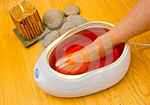 Woman foot in paraffin bath at the spa photo