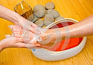 Woman foot in paraffin bath at the spa photo