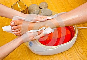 Woman foot in paraffin bath at the spa photo