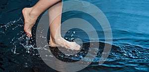 Woman foot step on blue Water in Splash