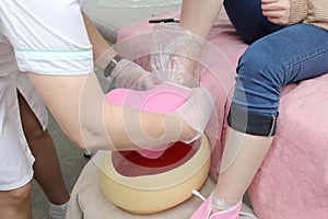 woman foot treatment in paraffin bath at the spa.