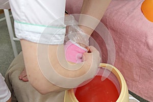 woman foot treatment in paraffin bath at the spa.
