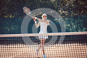 Woman forcefully playing tennis close to net