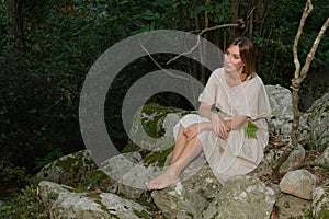 Woman in a forest sitting and relaxing as the sun goes down