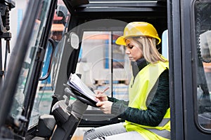 Woman forklift truck driver in an industrial area.