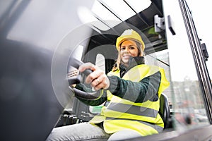 Woman forklift truck driver in an industrial area.