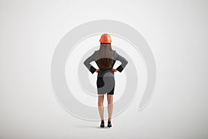 Woman in formal wear and construction helmet with her arms akimbo