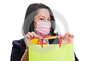 Woman in formalwear with mask presenting colourful shopping bag