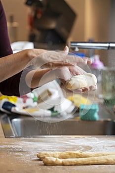 woman forms dough and beats flour into the surface of the easter braid