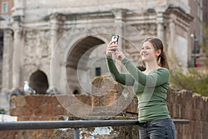 Woman in foro romano takes photos with her smartphone photo