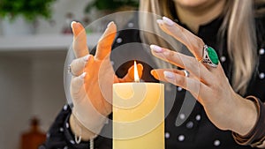 Woman fortune teller fortune telling on a candle. Selective focus.