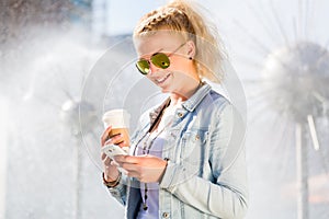 Woman at Fountain with Phone and coffee