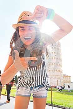 Woman framing in front of leaning tower of pisa