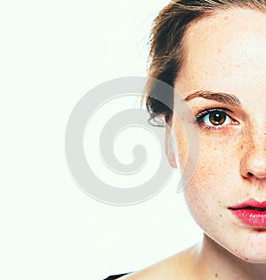 Woman freckle happy young beautiful studio portrait with healthy skin. Half face photo