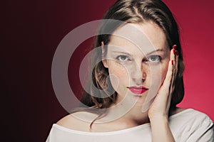 Woman freckle portrait on color background red and pink