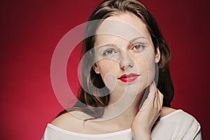 Woman freckle portrait on color background red and pink photo