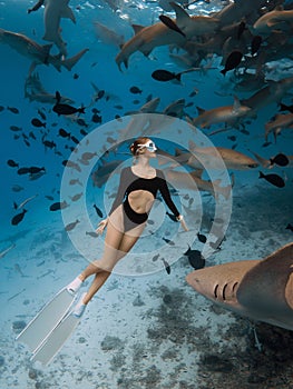 Woman freediver in a clear tropical water with nurse sharks in Maldives