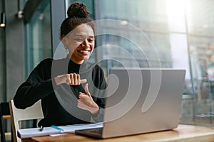 Woman freelance architect talking with client via video call and discuss project sitting in cafe