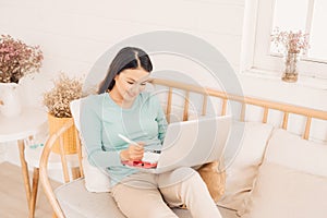 Woman freelancer female hands with pen writing on notebook at home or office