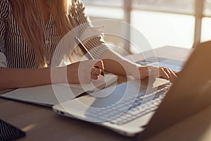 Woman freelancer female hands with pen writing on notebook at home or office photo