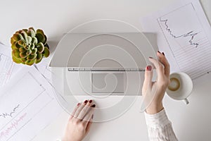 Woman freelancer finishing working and closes laptop with empty drink up cup of coffee and the end of working day. graphics